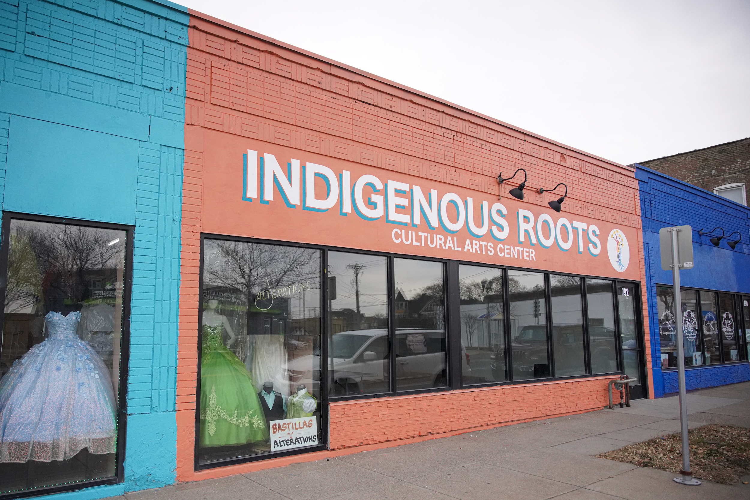 A multi-colored storefront with lettering that reads 'Indigenous Roots Cultural Arts Center'.